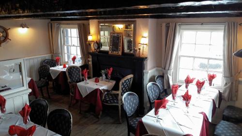 アーブロースにあるThe Old Brewhouseの赤いナプキンをテーブルに並べたレストラン