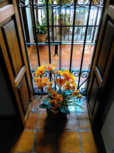 a vase filled with flowers on a tile floor at Casa Quintana in San Miguel de Allende