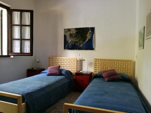 サンタ・マルゲリータ・ディ・プーラにあるVilletta nella Pineta Santa Margherita di Pulaのベッドルーム1室(ベッド2台付)、壁の地図