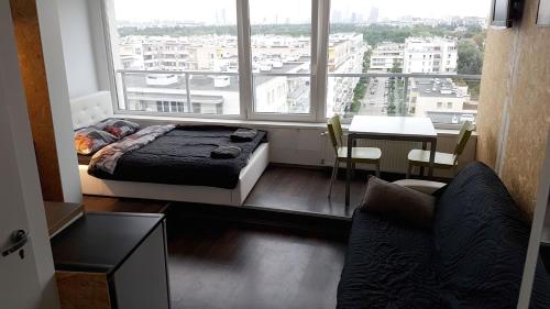 a bedroom with a bed and a large window at Walk distance to mokotow business park in Warsaw