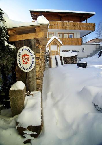 a sign in the snow in front of a house at Villa Krejza in Smokovce