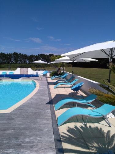 - une rangée de chaises et de parasols à côté de la piscine dans l'établissement Aubergerie, à Sauzon