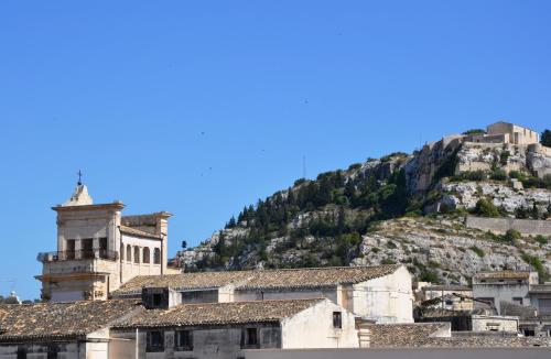 a building with a mountain in the background at Palazzo Favacchio - Patanè in Scicli