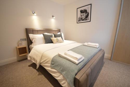 una camera da letto con un grande letto con asciugamani di St Anne's Court by Indigo Flats a Londra