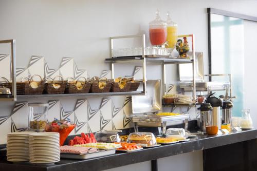 a buffet line with plates of food and drinks at Pontual Hotel in Bocaiúva