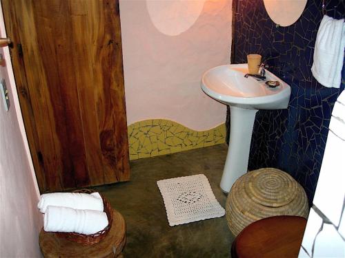 a small bathroom with a sink and a shower at Pousada Shangri-lá in Itacaré