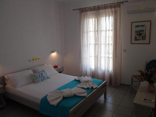 a bedroom with a bed with towels on it at Glyfada Beach Studios in Kastraki Naxou
