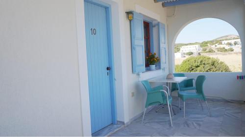 a balcony with a table and chairs and a window at Glyfada Beach Studios in Kastraki Naxou