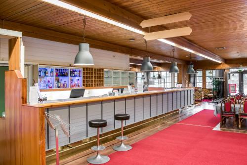 a bar in a restaurant with a red carpet at Apartment Kievarinhovi in Kempele