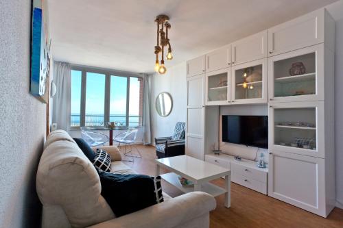 a living room with a couch and a tv at Candela's Beach Port in Masnou