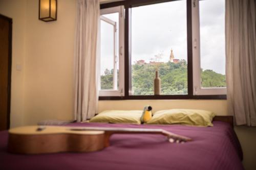 a bedroom with a window with a bird sitting on a bed at Swayambhu View Guest House in Kathmandu