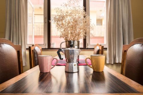 a table with three coffee mugs on top of it at Swayambhu View Guest House in Kathmandu