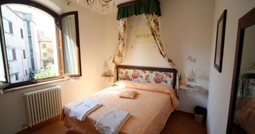 B&B Giuseppe في تشيوسي: غرفة نوم صغيرة مع سرير مع مظلة