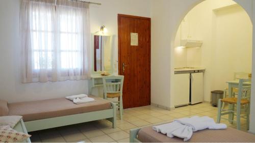 a small room with two beds and a kitchen at Glyfada Beach Studios in Kastraki Naxou
