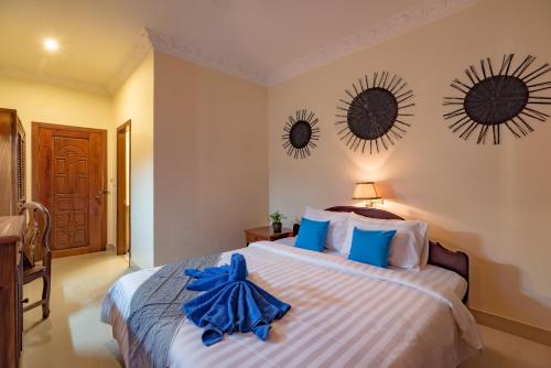 a bedroom with a bed and two mirrors on the wall at The Siem Reap Chilled Backpacker in Siem Reap