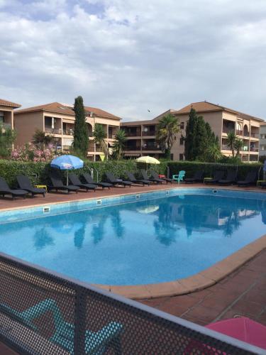 une grande piscine avec chaises et parasols dans l'établissement Les Marines de Morian, à Moriani-Plage
