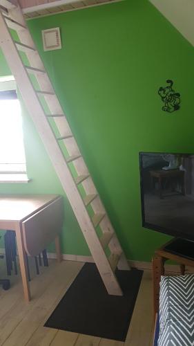 a room with a green wall with a wooden staircase at Pension Roager in Jejsing