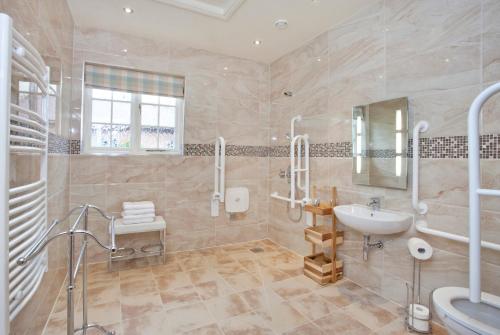 a large bathroom with a sink and a toilet at Holtby Grange Cottages in York