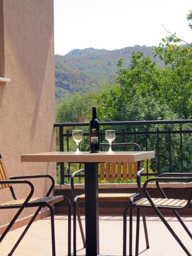 a table with a bottle of wine and two glasses at Estate & Winery San Duyevo in Rijeka Crnojevića