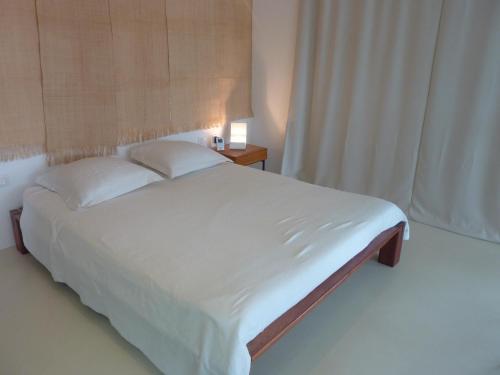 - une chambre avec un grand lit blanc et une fenêtre dans l'établissement Grand Loft EM33, à Hyères