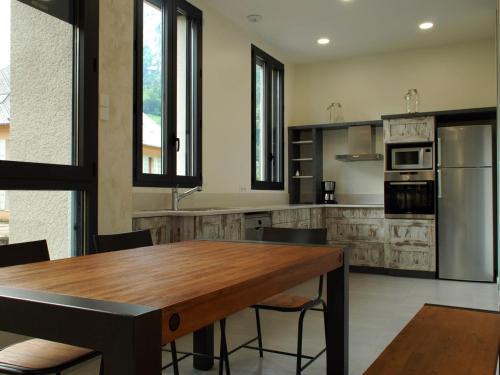 une cuisine avec une table en bois et un réfrigérateur dans l'établissement Le MOULIN des CHARTREUX - 1733, à Saint-Pierre-dʼEntremont