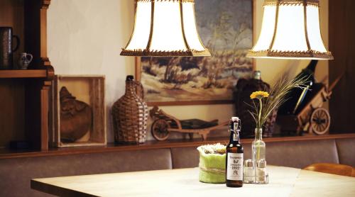 two bottles of wine sitting on a table with two lamps at Hotel Bergschlößchen in Simmern