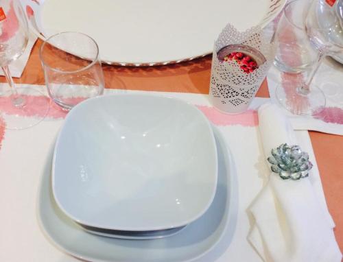 a white plate on a table with wine glasses at Apartments Alfacinha Ajuda in Lisbon