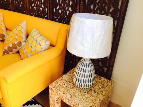 a lamp on a table next to a yellow couch at Apartments Alfacinha Ajuda in Lisbon