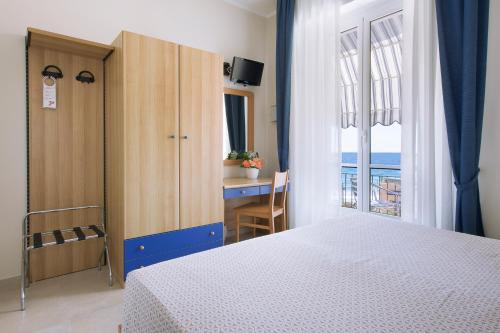 una camera da letto con un letto e vista sull'oceano di Albergo Teresa a Laigueglia