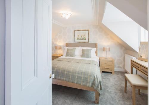 a bedroom with a bed and a desk with two lamps at Shore View Cottage in Inverness