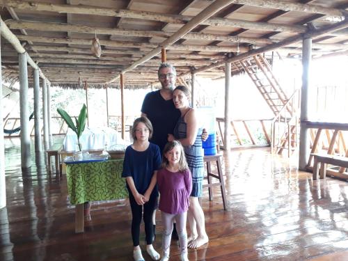 a family posing for a picture in a room at Tres Chimbadas Lake Lodge in Tambopata