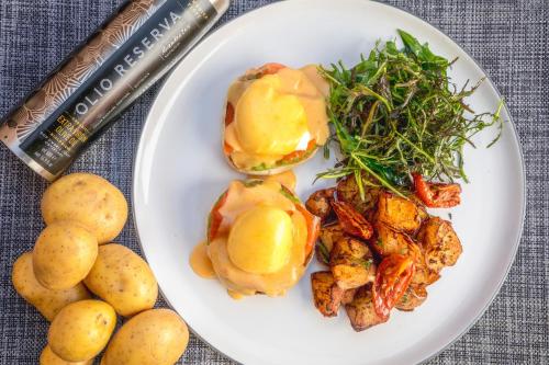 einen Teller mit Kartoffeln und einem Sandwich in der Unterkunft Villa Eyrie Resort in Malahat