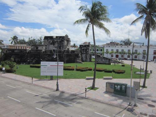 a park with palm trees in front of a building at Hotel Baluarte in Veracruz
