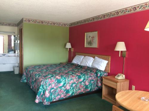 Habitación de hotel con cama y paredes rojas en Western Motel - Camilla, en Camilla