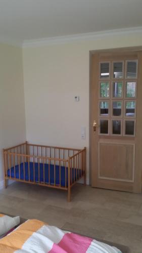 a room with a crib and a door at Ferienwohnung am Meer in Scharbeutz