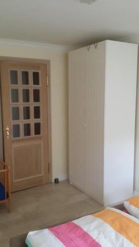 a bedroom with a white closet and a door at Ferienwohnung am Meer in Scharbeutz