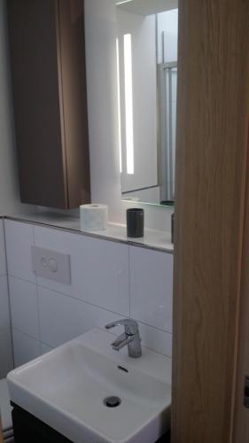 a bathroom with a white sink and a mirror at Ferienwohnung am Meer in Scharbeutz