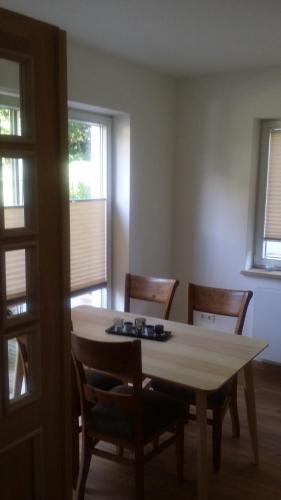 a dining room with a table and chairs and windows at Ferienwohnung am Meer in Scharbeutz