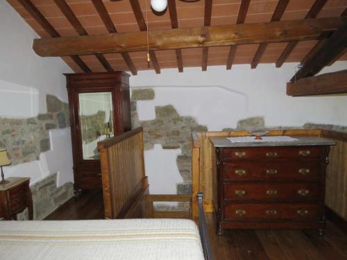 - une chambre avec un lit, une commode et un miroir dans l'établissement Santa Maria al Piano, à Reggello
