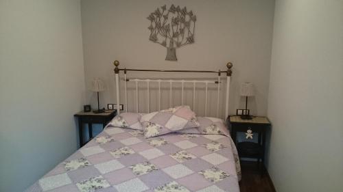 1 dormitorio con 1 cama con edredón rosa y blanco en Atico en centro Ribes de Freser, en Ribes de Freser
