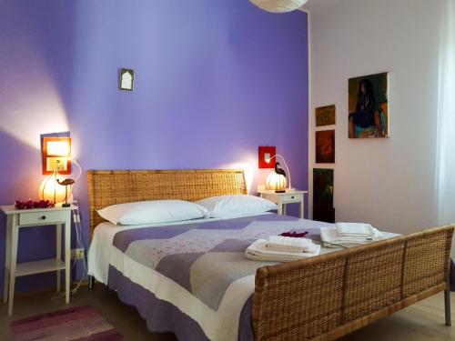 ヴェローナにあるCasa Musica Solの紫の壁のベッドルーム1室、ベッド1台(テーブル2台付)
