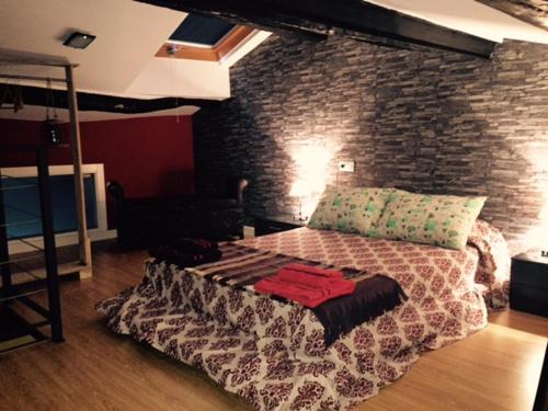Ce lit se trouve dans une chambre dotée d'un mur en briques. dans l'établissement Torremochada, à Cáceres