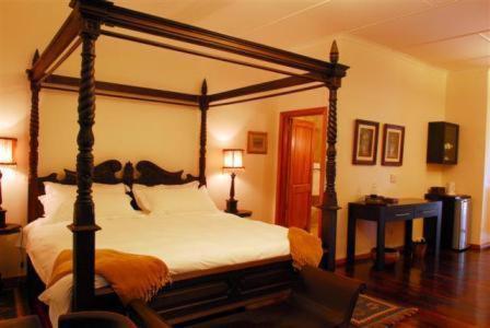 a bedroom with a canopy bed in a room at Kronenhoff Guesthouse in Kirkwood