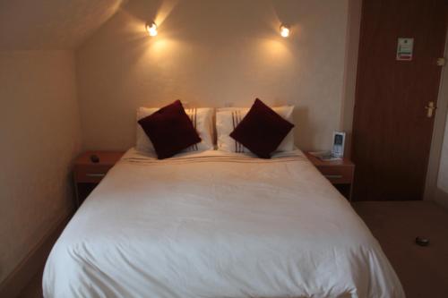 a bedroom with a large white bed with two pillows at Harbour House Bed & Breakfast - Wick in Wick