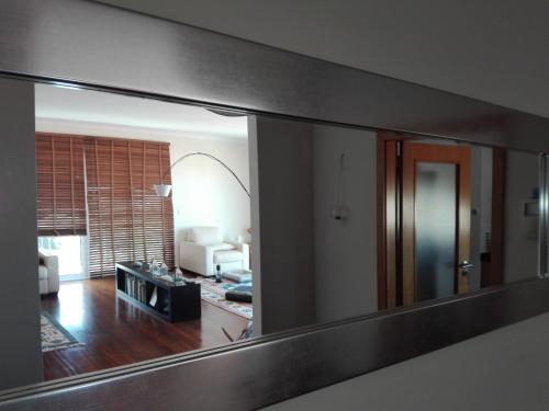 a mirror on a wall in a living room at Zen Caniço Apartment in Caniço
