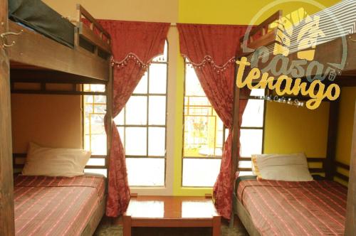 a bedroom with two bunk beds and a window at Hotel Casa Tenango in Cobán