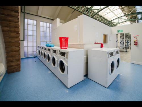 a laundry room with four washing machines in it at Grand Central Serviced Apartments in Auckland