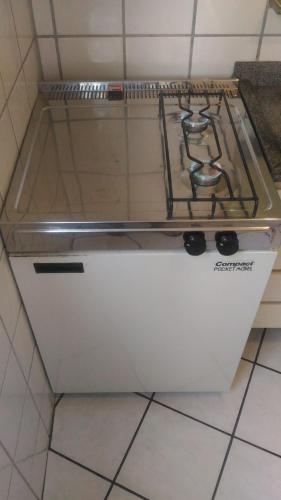 a stove top sitting on top of a kitchen floor at Apart Hotel Quartier Latin in Vitória