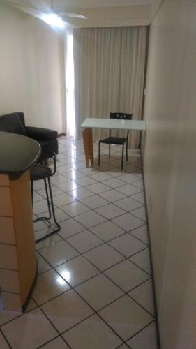 a living room with a table and chairs in a room at Apart Hotel Quartier Latin in Vitória