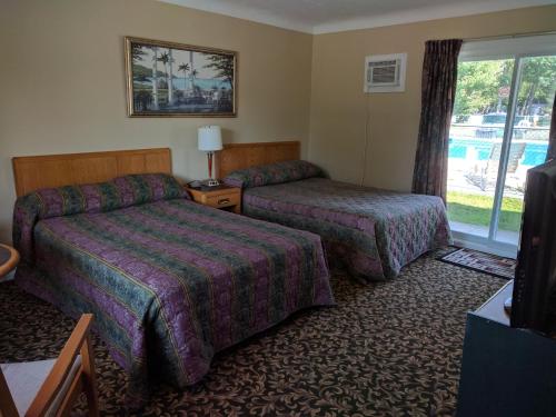 a hotel room with two beds and a window at Franklin Motel, Tent & Trailer Park in North Bay